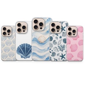 May include: Five smartphone cases arranged in a row, each featuring distinct ocean-themed designs. The patterns include blue and pink seashell motifs, a large blue scallop shell, and a central case depicting blue ocean waves with a single shell.