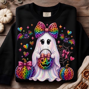 May include: A black crewneck sweatshirt featuring a central graphic of a white ghost wearing a large rainbow leopard print bow. The ghost holds a rainbow leopard print jack-o'-lantern bucket, flanked by two matching pumpkins, bats, hearts, and a spiderweb.