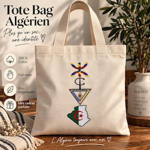 Peut inclure: Un sac fourre-tout en toile beige avec une broderie représentant un symbole berbère coloré, une forme géométrique noire et la carte de l'Algérie aux couleurs du drapeau national vert, blanc et rouge. Le texte indique Tote Bag Algérien.