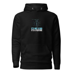 Peut inclure: Un sweat à capuche noir arborant un graphique de scarabée stylisé sur un fond quadrillé. Sous le motif, le texte IT'S NOT A BUG IT'S A FEATURE est inscrit en bleu clair et en blanc. Le sweat possède une poche kangourou sur le devant.