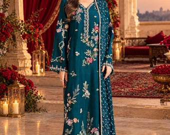 May include: A teal long-sleeved tunic dress featuring a V-neckline and intricate floral embroidery in shades of pink, white, and green. The garment is paired with matching straight-leg trousers and a coordinating sheer teal dupatta shawl.
