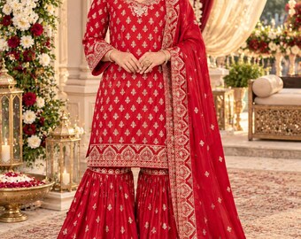 May include: A vibrant red three-piece ensemble featuring a long-sleeved tunic and wide-leg trousers, both adorned with intricate gold embroidery. A matching sheer red dupatta with a wide gold-embroidered border completes the set.