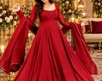 May include: A floor-length red dress with long sleeves, a square neckline, and a flared skirt. The bodice and sleeves feature small, evenly spaced white embellishments. A matching red dupatta with a white beaded border is draped over the arms.