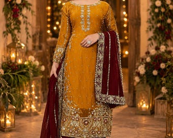 May include: A mustard yellow long-sleeved tunic featuring intricate silver embroidery and beadwork, paired with deep maroon wide-leg trousers and a matching maroon dupatta with a wide, heavily embellished gold and silver border.