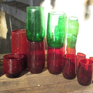 May include: A set of eight glass tumblers, four green and four red. The glasses are stacked in two rows, with the green glasses on top and the red glasses on the bottom.