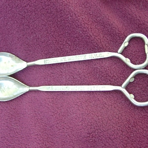 Puede incluir: Dos cucharas de bar plateadas vintage con extremos de abrebotellas. Una cuchara está marcada "HOTEL ST. MORITZ N.Y.C." y la otra "MAJESTIC HOTEL". Las cucharas tienen cuencos en forma de lágrima y mangos largos.