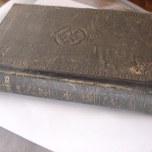 Puede incluir: Un libro antiguo encuadernado en cuero marrón oscuro con letras doradas en el lomo que dice "Saxon Grammar Reader".