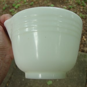May include: A white ceramic mixing bowl with a pouring spout. The bowl has three horizontal lines around the top.