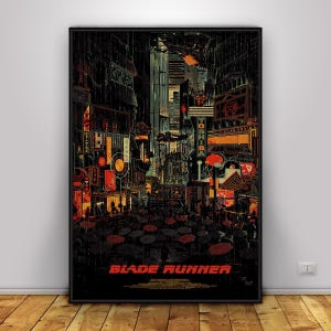 Peut inclure: Une affiche verticale représentant un paysage urbain sombre et pluvieux avec des enseignes néon orange et jaunes, dont une enseigne Toshiba. La scène montre une foule avec des parapluies sous des véhicules volants. Le texte Blade Runner est en rouge.