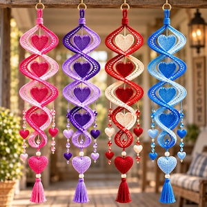May include: Four hanging spiral ornaments featuring crocheted heart patterns in pink, purple, red, and blue. Each piece includes a central twisted structure, dangling beaded accents, and a bottom tassel with a large crocheted heart.