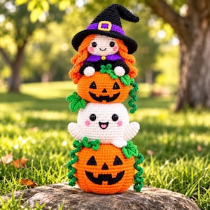 May include: A vertical stack of three crocheted figures: a witch with orange hair and a black hat, a small orange jack-o'-lantern, a white ghost with black eyes and pink cheeks, and a large orange jack-o'-lantern with green vine accents.
