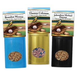 May include: Three memorial bird seed packets in blue, gold, and black. Each features a baseball-themed header with a bird, glove, and ball, plus text: Please feed the birds in loving memory of Brandon Weston, Thomas Coleman, or Johnathon Michael Dawson.
