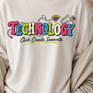 May include: A cream-coloured long-sleeve sweatshirt featuring the word TECHNOLOGY in large, colourful, retro-style bubble letters. Above the text is a graphic of a white cable with a Wi-Fi symbol. Below, the text reads Click. Create. Innovate.