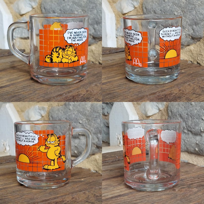 May include: Set of four glass mugs featuring Garfield the cat. Each mug has a different image of Garfield with a sunrise or sunset and a caption. The captions are "I've never seen a sunrise... I'm waiting for the movie", "Such a beautiful sunset... and me without a horse", "I've never seen a sunrise... I'm waiting for the movie", and "Such a beautiful sunset... and me without a horse".