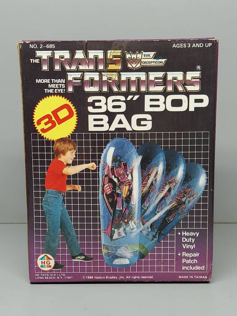 May include: A box for a 36-inch Transformers Bop Bag. The box is purple and black with a picture of a boy punching the bag. The bag is blue and white with a picture of Optimus Prime on it. The box says "More than meets the eye!" and "Evil Decepticon".