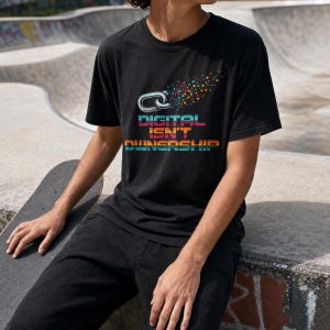 May include: A black short-sleeved t-shirt featuring a graphic of a silver chain link breaking into colorful digital pixels. Below the graphic, the text reads "DIGITAL ISN'T OWNERSHIP" in a multi-colored, retro-inspired gradient font style.