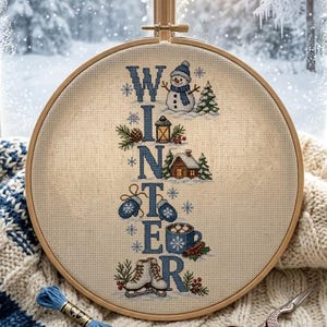 May include: A circular wooden embroidery hoop containing a cross-stitch pattern on beige fabric. The design features the vertical text WINTER in blue, accented with a snowman, a lantern, a cabin, blue mittens, a mug of cocoa, and ice skates.