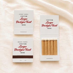May include: Three white matchbooks with custom red and black text. One closed matchbook labeled (FONT SIDE), one closed matchbook labeled (BACK SIDE) with a dark brown strike strip, and one open matchbook revealing a row of wooden matches.
