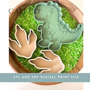 May include: A sage green dinosaur cookie cutter and two tan dinosaur footprint cookie cutters. The text CALI CO DIGITAL is visible in the top left corner, and the text STL AND 3MF DIGITAL PRINT FILE is visible at the bottom of the image.