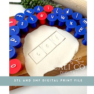Pode incluir: Um conjunto de carimbos de alfabeto de plástico azul e vermelho com letras brancas no topo, dispostos em semicírculo. Um pedaço de argila branca de modelar está marcado com as letras para formar a palavra cat. O texto CALI CO DIGITAL STL AND 3MF DIGITAL PRINT FILE é visível.