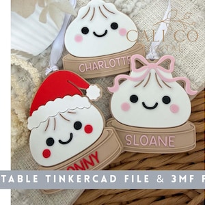 May include: Three white dumpling-shaped ornaments with smiling faces, each sitting on a tan base. One wears a red Santa hat, one has a pink bow, and one is plain. The bases feature the names Charlotte, Sloane, and Jonny in raised lettering.
