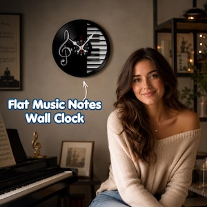 May include: A circular wall clock featuring a black vinyl record design with a white treble clef on the left side and a piano keyboard pattern on the right. The clock has white hour and minute hands and a red second hand. Text reads Flat Music Notes Wall Clock.