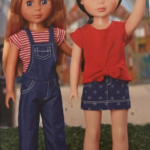 Puede incluir: Dos muñecas de pie una al lado de la otra. La muñeca de la izquierda tiene el pelo largo de color marrón rojizo y viste una camisa a rayas rojas y blancas bajo un peto vaquero. La de la derecha tiene el pelo negro corto, una blusa roja y falda azul.