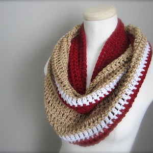 May include: A crocheted infinity scarf with stripes of gold, white, and red.