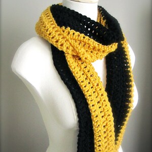 May include: A crocheted scarf with black and gold stripes. The scarf is made with a simple crochet stitch and is a great way to add a pop of color to any outfit.