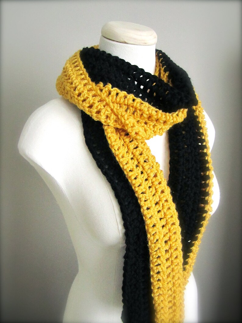 May include: A crocheted scarf with black and gold stripes. The scarf is made with a simple crochet stitch and is a great way to add a pop of color to any outfit.