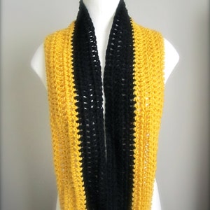 May include: A crocheted infinity scarf with black and yellow stripes. The scarf is made with a simple stitch pattern and is a great way to add a pop of color to any outfit.