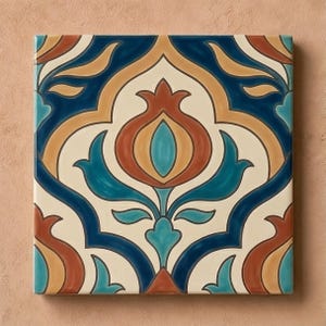 May include: A square ceramic tile featuring a symmetrical pattern of stylized pomegranate motifs in shades of deep blue, terracotta orange, and turquoise, set against a cream-colored background with smooth, glossy, and reflective surfaces.