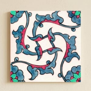 May include: A square ceramic tile featuring a white background with a central swirling pattern of blue and pink floral vines. The corners of the tile display blue, pink, and green flower motifs, creating a symmetrical and decorative design.