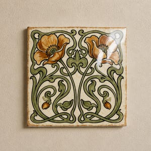 May include: A square ceramic tile featuring a symmetrical design of two orange poppy flowers with dark centres, surrounded by flowing green stems and leaves on a cream-coloured background. The tile has a glossy finish and a subtle crackle texture.