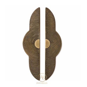 May include: A pair of elongated, semi-circular brass door handles featuring a detailed concentric line pattern and a smooth, solid semi-circle accent at the center of each piece. The metal has a dark, aged finish with the text ASMABRASS visible.