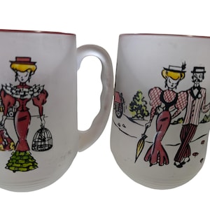 May include: Two frosted glass mugs featuring colorful illustrations of figures in vintage-style clothing. The left mug shows a person with a birdcage and luggage near a train, while the right mug depicts a couple walking together with an umbrella.