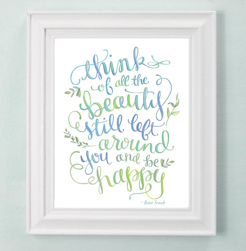 May include: A white framed print with a blue and green watercolor quote that reads "Think of all the beauty still left around you and be happy" - Anne Frank.