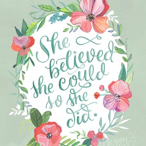 Può includere: Una stampa artistica con la citazione "She believed she could so she did" in corsivo turchese, circondata da una ghirlanda floreale. La ghirlanda comprende fiori rosa e rossi e foglie verdi, su sfondo verde chiaro.