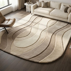 May include: A large, oval-shaped area rug featuring a textured, multi-layered design with flowing, wave-like patterns in varying shades of beige, cream, and light brown, creating a dimensional look across the surface of the floor covering.