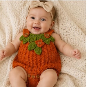 May include: A crochet baby romper in a vibrant orange pumpkin color, featuring a green leaf and orange flower applique at the neckline, brown wooden buttons on the straps and bottom, and a matching beige bow headband with a soft texture.