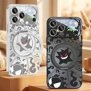 May include: Two smartphone cases featuring a graphic of a purple, spiky creature with red eyes and a wide grin. The cases have a circular ring stand on the back, a camera lens cutout, and a segmented design with swirling patterns in black, grey, and white.