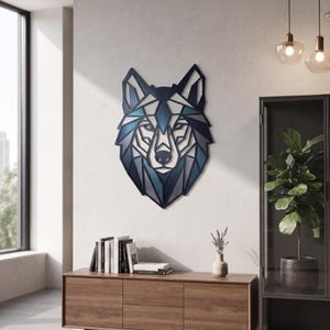 May include: A geometric wall art piece shaped like a wolf head, featuring a layered design with shades of dark blue, navy, and teal. The structure is composed of angular, interconnected lines and shapes that form the facial features of the wolf.