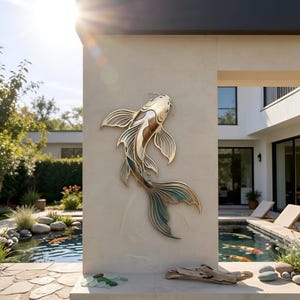 Könnte beinhalten: Eine Wandskulptur aus Metall in Form eines Koi-Karpfens mit geschichteten Ausschnitten in Gold-, Bronze- und Petroltönen. Der Fisch ist in einer Schwimmbewegung mit detaillierten Flossen und Schuppen auf einer hellen Steinsäule dargestellt.