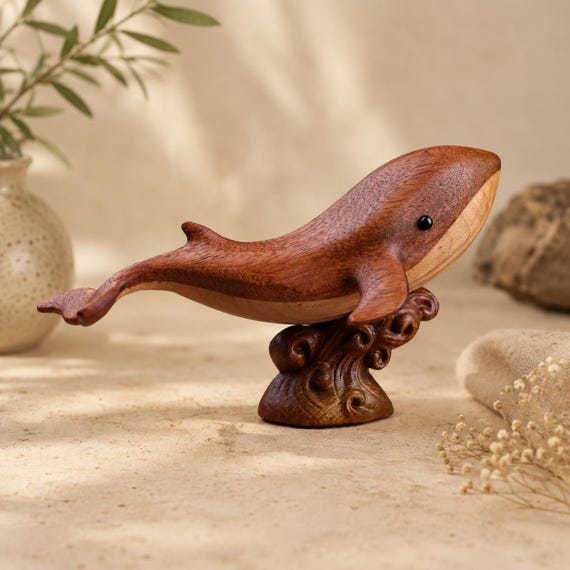 Hand-carved blackwood whale sculpture with magnetic elements — a desk piece that feels like a tiny art gallery acquisition, not a souvenir shop find.
