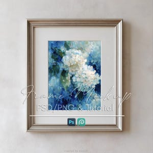 May include: A silver-toned picture frame containing an oil painting of white hydrangea flowers against a deep blue background. The frame includes a white mat board. Text overlay reads Frame Mockup PSD/PNG & Tutorial with Adobe icons.