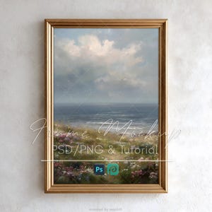 May include: A vertical rectangular gold-toned picture frame containing a landscape painting of a coastal scene with a grassy foreground filled with small pink and white flowers, a dark blue ocean, and a cloudy sky. The text Ps and a logo are visible.