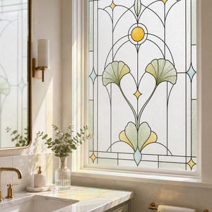 May include: A window film featuring a stained glass design with a central botanical motif of pale green ginkgo leaves, a yellow circular accent, and geometric lines in black, white, and soft blue, creating a decorative privacy screen for glass.