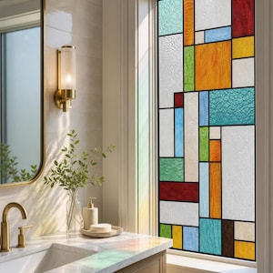Puede incluir: Una ventana rectangular que presenta un panel de vidrieras con un patrón de cuadrícula geométrica. El diseño consta de varios paneles rectangulares en tonos rojo, naranja, amarillo, verde, azul y blanco, separados por finas líneas de plomo.
