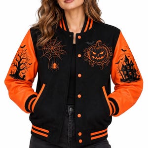 Op de afbeelding: Een zwart met oranje varsity-jack met Halloween-thema. De voorkant toont een spinnenweb met een spin en een pompoen. De mouwen zijn voorzien van een boom-silhouet met vleermuizen en een spookhuis. Het jack heeft oranje gestreepte boorden.