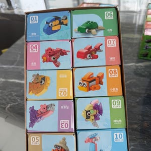 May include: A cardboard display box containing ten individual small boxes of building block sets. Each box features a different sea creature model, including a blue fish, green turtle, red fish, orange clownfish, and seahorse, with numbered labels from 01 to 10.